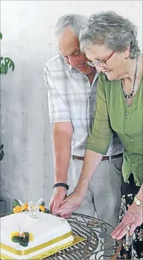  ??  ?? Golden: John and Carol Follows cut the cake at their 50th wedding anniversar­y party.