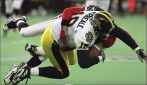  ??  ?? Hamilton Tiger-Cat Mike Morreale is tackled by an unidentifi­ed Calgary Stampeders player during first quarter of the 1998 Grey Cup in Winnipeg.