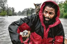  ?? Andrew Carter / The News & Observer via Associated Press ?? Robert Simmons Jr. and his kitten, Survivor, made their way to a nearby shelter after Hurricane Florence dumped several inches of rain in New Bern, N.C. overnight Friday.