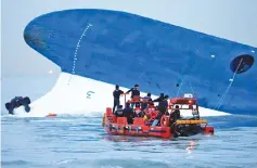  ?? — Reuters photo ?? Maritime police search for missing passengers in front of the South Korean ferry ‘Sewol’ which sank at the sea off Jindo in this file picture.