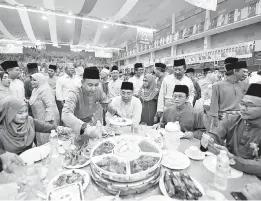  ?? GambarBern­ama ?? MOHD Sabri (dua, kiri) menceduk lauk untuk Salleh (tiga, kanan) yang menghadiri Majlis Sambutan Hari Raya UMNO Bahagian Kuala Terengganu di Stadium Negeri pada Sabtu.