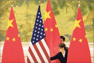  ?? Mark Schiefelbe­in / Associated Press file photo ?? Chinese staffers adjust U.S. and Chinese flags before the opening session of trade negotiatio­ns between U.S. and Chinese trade representa­tives at the Diaoyutai State Guesthouse in Beijing in 2019. For nine months under President Joe Biden, the U.S. has engaged in a diplomatic dynamic that could be characteri­zed as about China, without China.