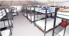  ?? SOURCE: DEPARTMENT OF HEALTH AND HUMAN SERVICES ?? Neat rows of bunk beds accommodat­e about 300 teens in air-conditione­d tents near the border crossing at Tornillo, Texas. The residents of the tent city also have dining hall and a large screen for movies.