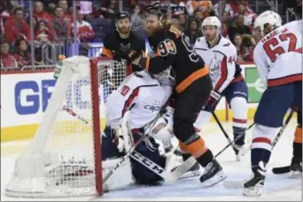  ?? NICK WASS — THE ASSOCIATED PRESS ?? Flyers right wing Jakub Voracek (93) collides with Washington Capitals goaltender Braden Holtby (70) during the second period on Sunday in Washington. Capitals left wing Carl Hagelin (62) and defenseman Brooks Orpik (44) look on.