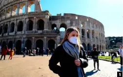  ??  ?? 1. A tourist outside Rome’s empty Colosseum. 1