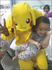  ??  ?? A Curtin student, Arvin Kumar in Pikachu costume having fun with a child in the Paediatric Ward.