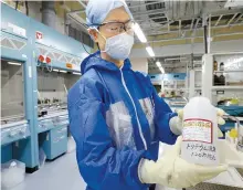  ?? AFP-Yonhap ?? A Tokyo Electric Power Company (TEPCO) researcher shows processed water where tritium remains at a lab in Fukushima Dai-ichi nuclear plant in Okuma, Fukushima prefecture, Oct. 2.