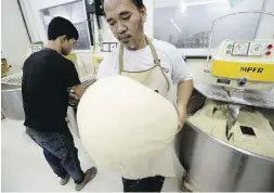  ??  ?? An employee carries dough at the Tan Ek Tjoan factory. A voracious appetite for sandwiches and baked goods has turned Indonesia into the No. 2 importer of wheat.