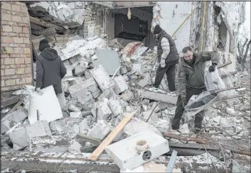  ?? Roman Hrutsyna The Associated Press ?? People go through a destroyed house after a Russian missile attack Thursday in Hlevakha, in the Kyiv region of Ukraine. Air attacks continued Friday, killing at least 10.