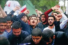  ?? VAHID SALEMI / AP ?? Iranian demonstrat­ors chant slogans during a protest in front of the long-closed US embassy in Teheran on Wednesday in response to President Donald Trump’s decision to pull out of the nuclear deal with Iran and renew sanctions.