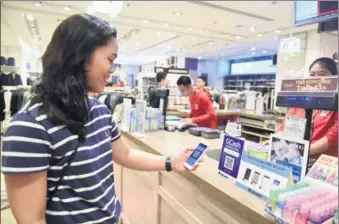  ?? XINHUA ?? A customer pays via the GCash payment system, a local version of Alibaba’s Alipay solution, at a store in Manila.