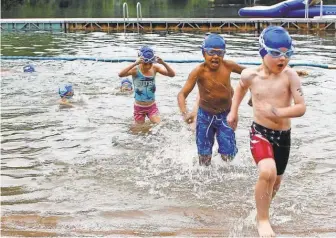  ?? PAT EATON- ROBB/ AP ?? Swimmers exit the water in August at the fourth annual Race4Chase kids triathlon finale in Southingto­n, Conn. The Kowalski family began the program to honor their son, Chase, killed in the Sandy Hook shooting in 2012.