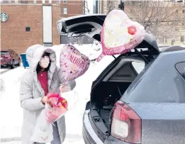  ?? CHARLES REX ARBOGAST/AP ?? Ellen Yun loads Valentine’s Day gifts for her mom, sister and brother in-laws, nephew and her two children Saturday in Chicago. This Valentine’s Day, Americans are searching to celebrate love amid the isolation and heartache of the pandemic.