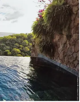  ??  ?? À esq., turista observa os montes Pitons enquanto relaxa na piscina de borda infinita de um resort. Abaixo, uma das tranquilas praias na ilha de Santa Lúcia.