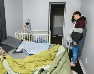  ?? CHRIS SWEDA/CHICAGO TRIBUNE ?? Venezuelan migrant Jhonathan Aleman, 28, looks at the crib of his youngest son, Theo, who died after a car accident last Friday.