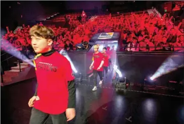  ?? DAVID MCNEW/AFP ?? Shanghai Dragons player Ado (left) enters the auditorium to play the New York Excelsior during Stage 3 of Overwatch League Inaugural Season video game play at Blizzard Arena in Burbank, California, on May 4.