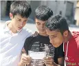  ??  ?? Boys in Aleppo read a leaflet dropped by the Syrian regime over safe passage