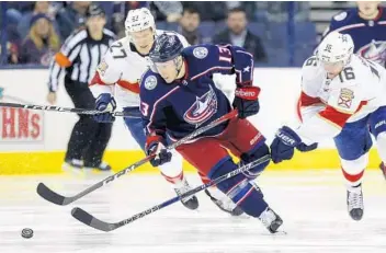  ?? PAUL VERNON/AP ?? Columbus Blue Jackets forward Cam Atkinson, center, chases the puck against Florida’s Nick Bjugstad, left, and Aleksander Barkov.