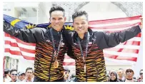  ?? - Gambar BERNAMA ?? MOHD Harrif (kiri) dan abangnya Mohd Zamri bergambar bersama-sama selepas masing-masing berjaya merangkul pingat emas dan gangsa dalam acara kriterium di sini, pada Isnin.