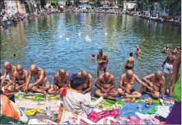  ??  ?? People perform rituals on Sarvpitri Amavasya in Banganga tank in Walkeshwar.