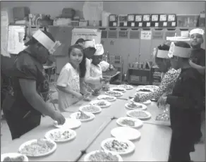  ??  ?? Snacks: Retta Brown Elementary third graders count out 100 snacks during a Day 100 celebratio­n.