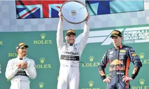  ??  ?? Aap/julian Smith/via REUTERS Mercedes’ Valtteri Bottas (C) holds aloft the winner’s trophy after winning the Formula One F1 Australian Grand Prix at the Albert Park Grand Prix Circuit in Melbourne, Australia, on March 17, 2019.