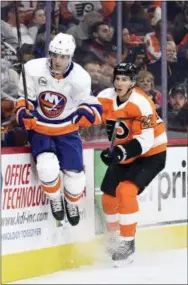  ?? DERIK HAMILTON — THE ASSOCIATED PRESS ?? The Islanders’ Thomas Hickey, left, leaps to avoid a hit from the Flyers’ Dale Weise during the second period.