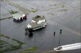  ?? STEVE HELBER - THE ASSOCIATED PRESS ?? A pickup truck drives on a flooded road past a farm house that is surrounded by flooded fields from tropical storm Florence in Hyde County, NC., Saturday, Sept. 15.