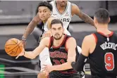  ?? DARREN ABATE/ASSOCIATED PRESS ?? Chicago’s Tomas Satoransky, center, prepares to pass to new teammate Nikola Vucevic, just acquired from Orlando. Vucevic had 21 points and nine rebounds vs. the Spurs in his Bulls debut.