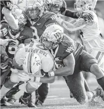  ?? .ANDREW DYE/WINSTON-SALEM JOURNAL ?? Virginia running back Wayne Taulapapa is tackled by a group of Wake Forest defenders after a run Saturday in WinstonSal­em, North Carolina.