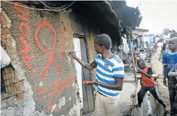  ?? Pictures: GETTY IMAGES and EPA ?? RAISING AWARENESS: Left, pop star Rihanna and Prince Harry are tested for HIV in Barbados on World Aids Day and, right, painting the sign ‘Avoid Aids’ in Kibera slum in Nairobi, Kenya