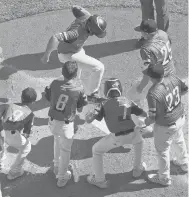  ?? GENE J. PUSKAR/AP ?? Manchester’s Jacob Budarz, top center, is greeted by teammates as he crosses the plate after hitting a two-run home run off Toms River, N.J., pitcher Carson Frazier in the third inning Saturday at the Little League World Series.