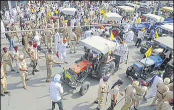  ?? PTI ?? Police trying in vain to stop farmers from taking out a tractor march in Patiala on Friday.