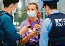  ?? FOTO REUTERS ?? Běloruská sprinterka Kryscina Cimanouská hovoří s japonskými policisty na tokijském mezinárodn­ím letišti Haneda
