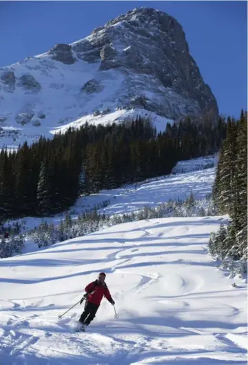  ?? TODD KOROL PHOTOS FOR THE TORONTO STAR ?? A skier slices up the snow on a run under a rocky peak at Fortress Mountain in Kananaskis, Alta.