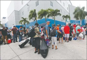  ?? AP/GERALD HERBERT ?? Evacuees stand in line to enter the Germain Arena, which is being used as a fallout shelter, on Saturday in advance of Hurricane Irma in Estero, Fla.