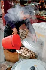  ??  ?? A vendor pours a bucket of boys' urine into a pot of hard-boiled eggs at his stall in Dongyang, Zhejiang province (REUTERS)