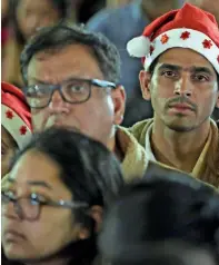  ??  ?? FOCUSED.. A man wears Santa head gear while attending the midnight Mass.