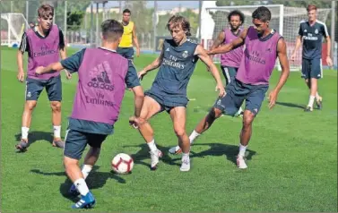  ??  ?? AYER EN VALDEBEBAS. Modric, en un momento de la sesión de entrenamie­nto junto a Varane.