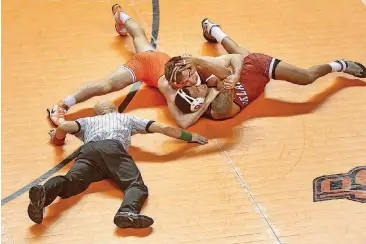  ?? [PHOTO BY IAN MAULE, TULSA WORLD] ?? Oklahoma State’s Chandler Rogers, left, pins Oklahoma’s Yoanse Mejas during the Bedlam wrestling match on Sunday at Gallagher-Iba Arena. The No. 1-ranked Cowboys routed the Sooners 37-3 and finished the regular season unbeaten for the first time since...