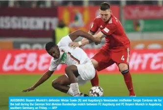  ??  ?? AUGSBURG: Bayern Munich’s defender Niklas Suele (R) and Augsburg’s Venezuelan midfielder Sergio Cordova vie for the ball during the German first division Bundesliga match between FC Augsburg and FC Bayern Munich in Augsburg, southern Germany, on Friday. — AFP