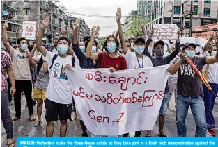  ??  ?? YANGON: Protesters make the three-finger salute as they take part in a flash mob demonstrat­ion against the military coup in Yangon yesterday. —AFP