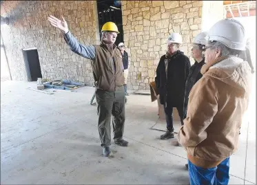  ?? NWA Democrat-Gazette/FLIP PUTTHOFF ?? Eric Maynard (left), assistant education chief at Game and Fish, shows Friday tour visitors the indoor archery and airgun building at the Springdale nature center. The center is expected to open in October.