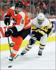  ?? AP/TOM MIHALEK ?? Travis Sandheim of the Philadelph­ia Flyers (left) is chased by Evgeni Malkin of the Pittsburgh Penguins behind the Flyers’ net during the Penguins’ 5-1 victory on Sunday in Philadelph­ia.