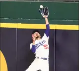  ?? Curtis Compton / Associated Press ?? Los Angeles Dodgers right fielder Mookie Betts makes a catch and robs a home run from the Atlanta Braves’ Freddie Freeman during the fifth inning in Game 7 of the National League Championsh­ip Series on Sunday in Arlington, Texas.