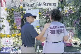  ?? LYNNE SLADKY — THE ASSOCIATED PRESS ?? Omy Llaneras, left, Miami Beach police chaplain, stands with a woman Saturday at a makeshift memorial near the Champlain Towers South condo building, where scores of victims remain missing more than a week after it partially collapsed.