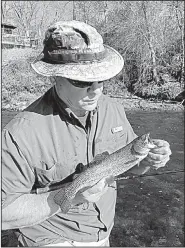  ?? Arkansas Democrat-Gazette/BRYAN HENDRICKS ?? Rusty Pruitt of Bryant admires a rainbow trout he caught last week on the Little Red River near Heber Springs.