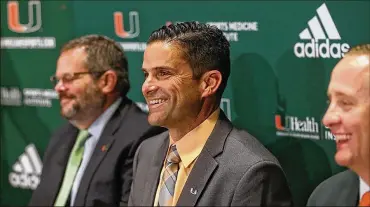  ?? PATRICK FARRELL / MIAMI HERALD ?? Sitting between David Epstein (left), Board of Trustees and Athletic Director Blake James, Manny Diaz (center) gets introduced as the University of Miami’s 25th head football coach in program history Jan. 2.