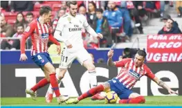  ??  ?? MADRID: Real Madrid’s Welsh forward Gareth Bale (C) vie for the ball with Atletico Madrid’s Colombian defender Santiago Arias (L) and Atletico Madrid’s Uruguayan defender Jose Gimenez during the Spanish league football match Club Atletico de Madrid against Real Madrid. —AFP