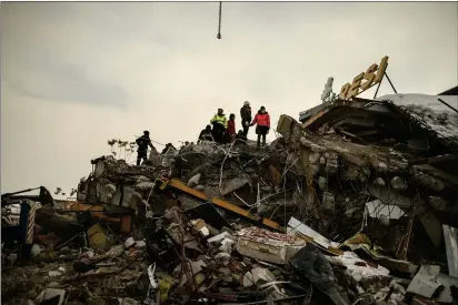  ?? PHOTOS BY EMRAH GUREL — THE ASSOCIATED PRESS ?? Rescue workers search for survivors at a collapsed building in Malatya, Turkey, on Tuesday.